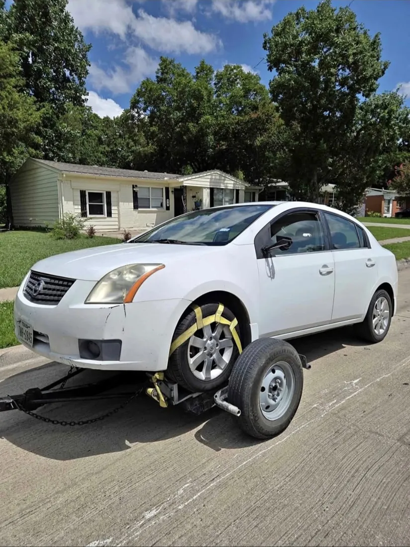 Nissan Sentra blanco sobre el remolque de Portillo.